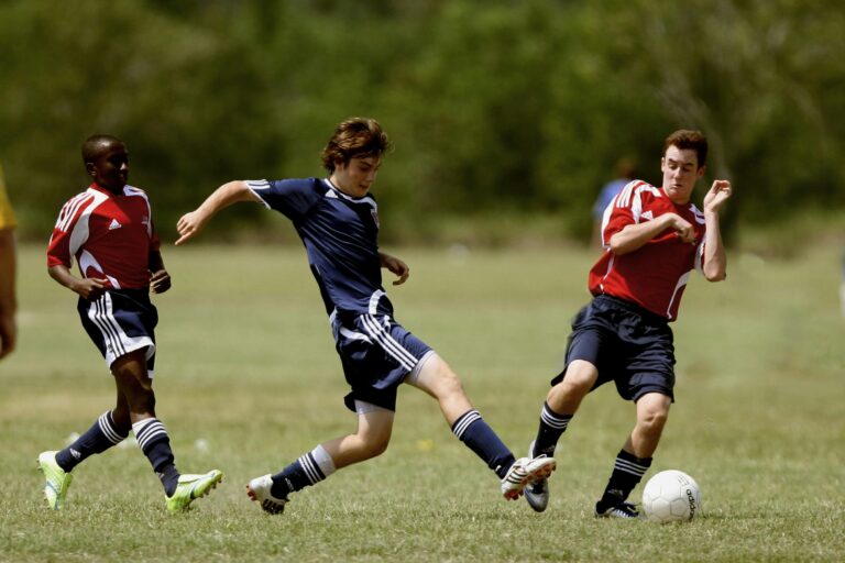 Teenage soccer players in action during an outdoor match showcasing skill and competition.